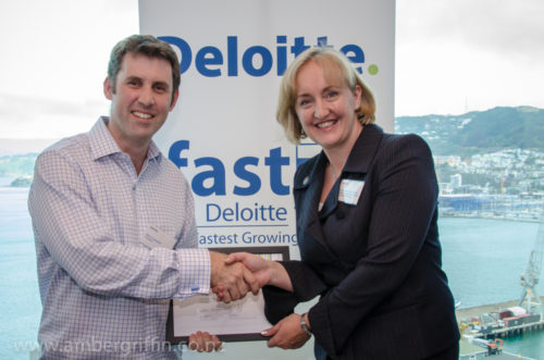 Glenn Campbell accepting a Deloitte Technology Fast 500 award for Tourwriter, Wellington harbour behind
