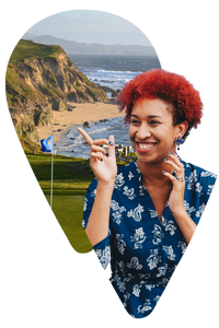 Woman wearing blue pointing at a picture of a golf course