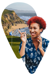 Travel-designer-in-California Woman wearing blue pointing at a picture of a golf course