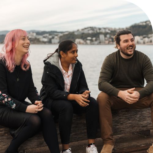 Three happy professionals sitting at the waterfront