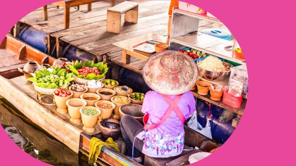 A local producer organising her stock at the floating market in Thailand.