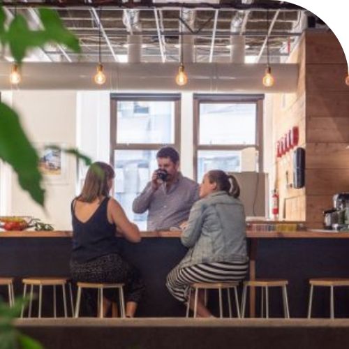 3 people sitting at a bench in the Wellington office