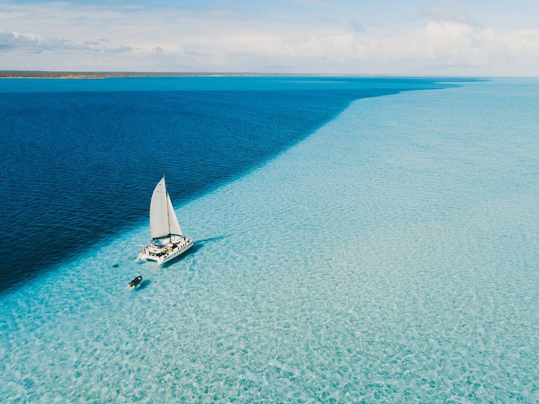Shore Thing, Sail Ningaloo's 51-foot catamaran, under sail over the clear waters of Ningaloo Reef