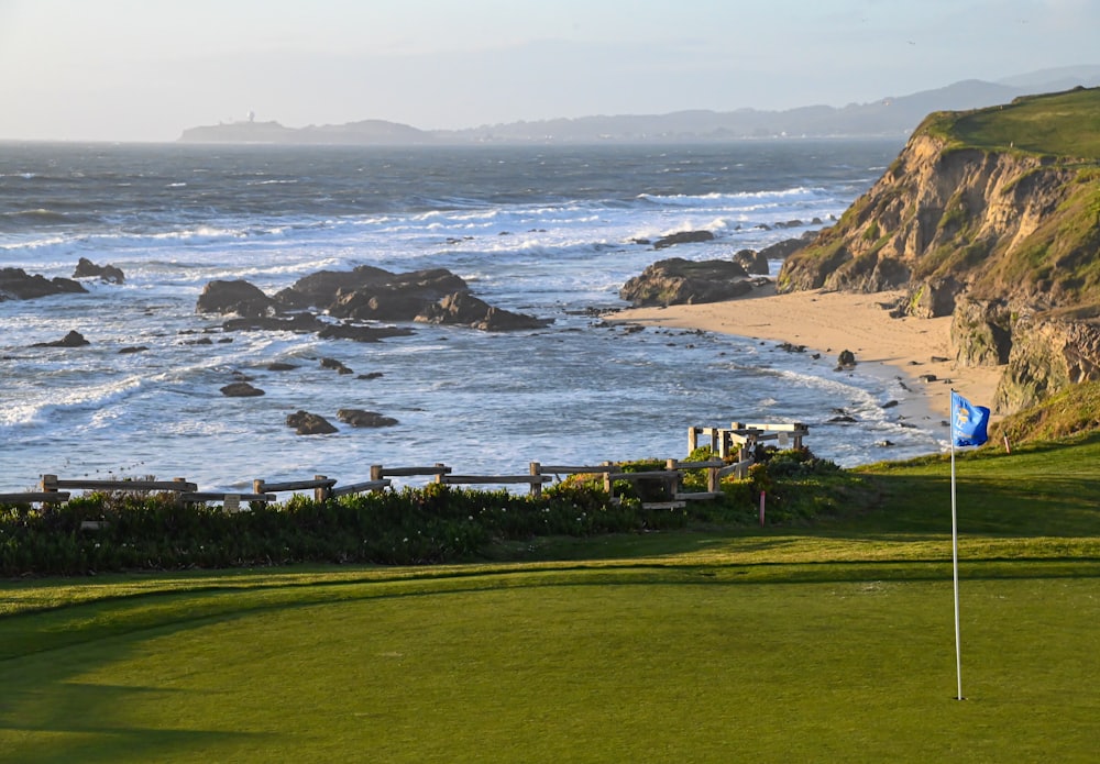 Oceanfront golf green and flagstick at a luxury California coastal golf course curated by Saunter Luxury Experiences