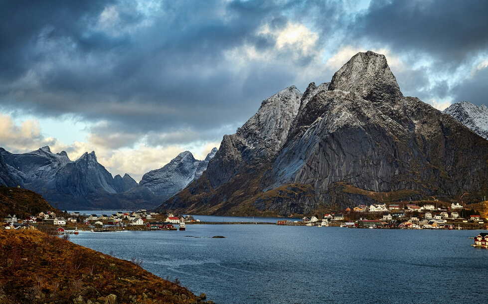 Hikers enjoying a sunset over the Norwegian coast, a luxury travel experience with Elan Norway
