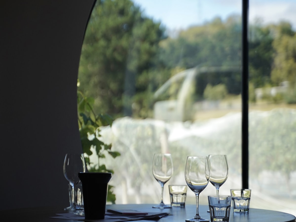 Wine glasses set on a table overlooking a sunlit vineyard on a small-group Western Australia wine tour